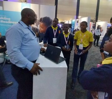 ICTAZ President Clement Sinyangwe engages with pupils from Matero Boys Secondary School and NetOne at the Intel stand during the 2022 African Innovation Ministerial Summit